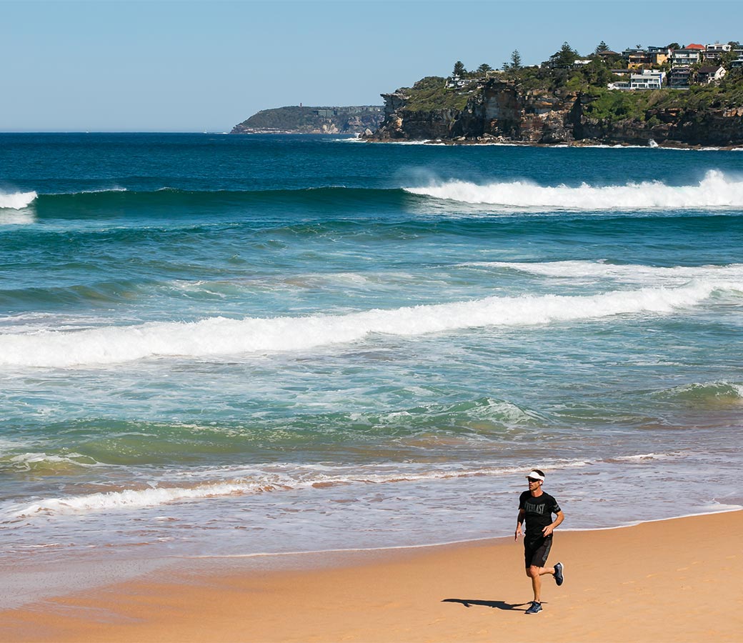 The Falls Estate - man jogging on Dee Why beach